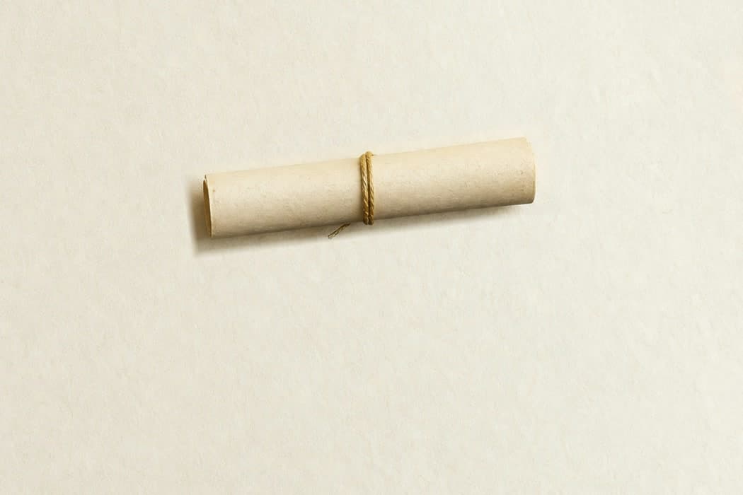 A printed letter rolled and tied with twine