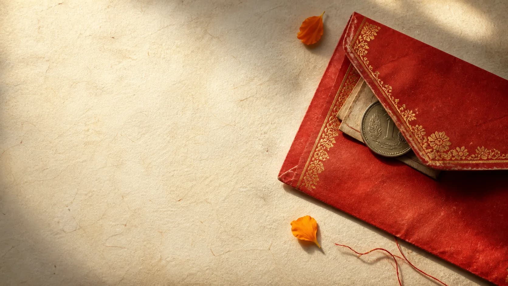 A red shagun lifafa with a one-rupee coin tucked beneath its flap.